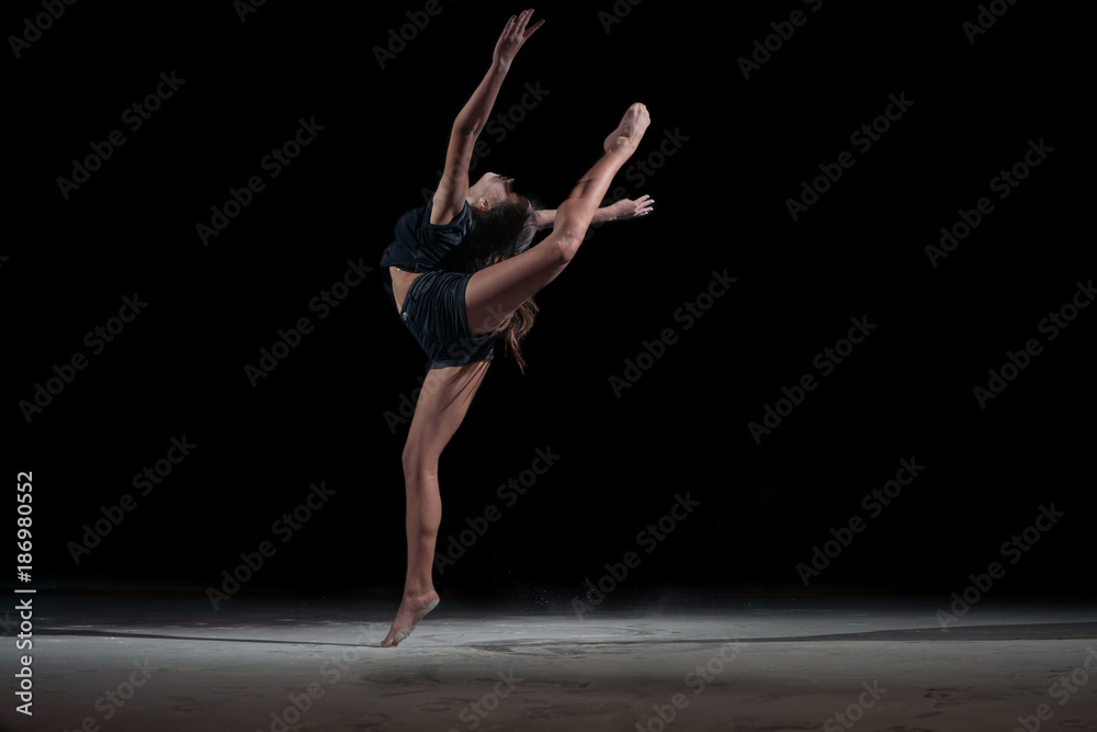 Girl gymnast in a jump with a twine