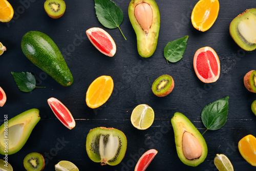 Fruit on a wooden background. Avocado, lime, orange, grapefruit and kiwi. Top view. Free space for your text.