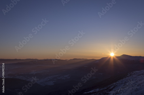 Sunrise in the mountains. The sun rises from behind the mountains. Western Ukraine. Carpathians.