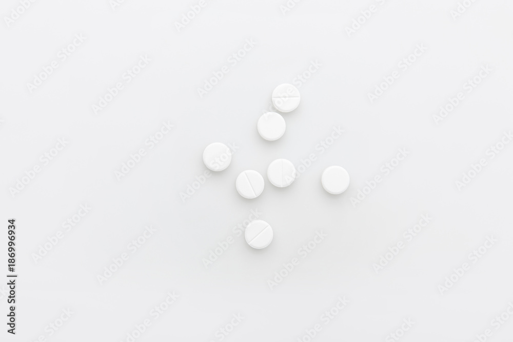 scattered white pills isolated on white background scattered white pills isolated on white background