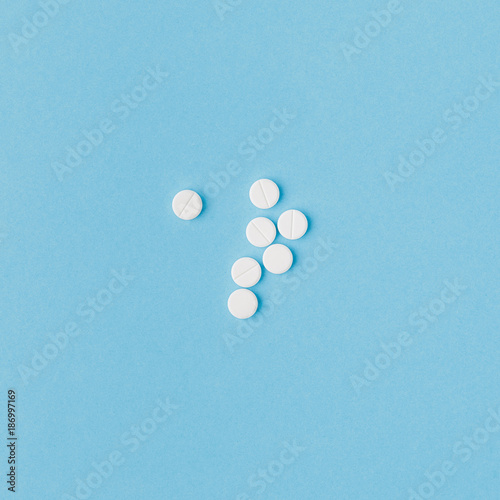 scattered white pills isolated on blue background