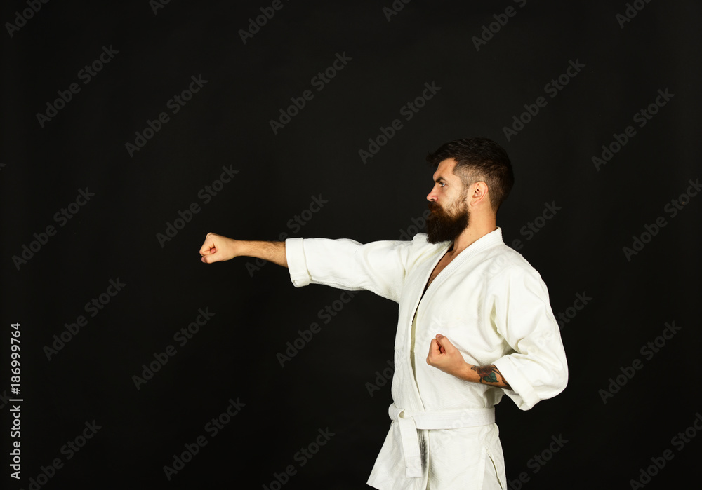 Karate man with strict face in uniform. Man with beard