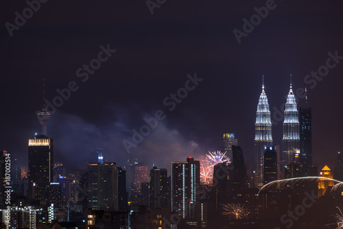 Photography KUALA LUMPUR, MALAYSIA - 1ST JANUARY 2018; Fireworks explode near Malaysia's landmark Petronas Twin Towers during New Year celebrations in Kuala Lumpur