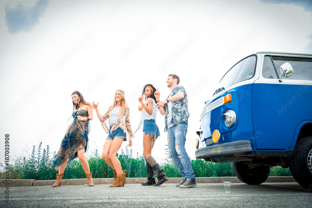 Obraz premium Happy friends driving a vintage minivan
