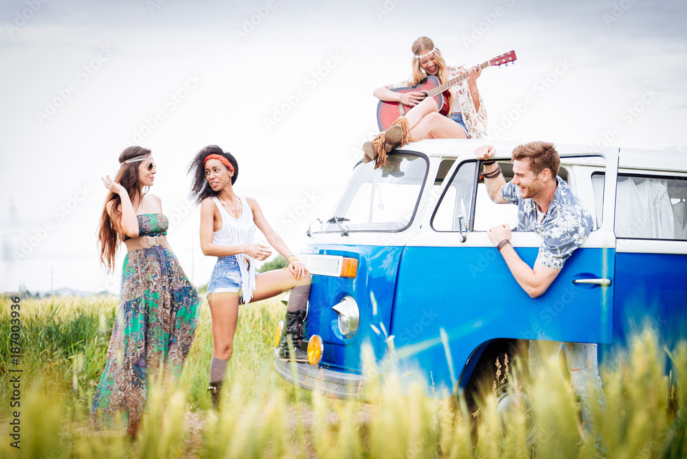 Obraz premium Happy friends driving a vintage minivan