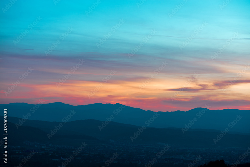 Romantic, bright and colorful sunset over a mountain range in Transilvania. Beautiful, colorful autumn background.