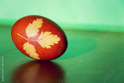 Brown-red Easter grass decorated egg colored with onion infusion