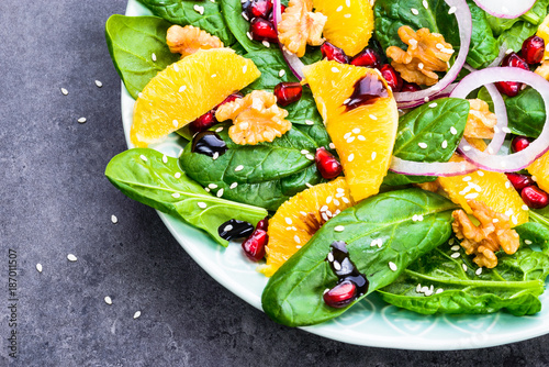 Salad with spinach leaves and orange, pomegranate and nuts.Light healthy vitamin salad bowl text space.Diet and detox concept.