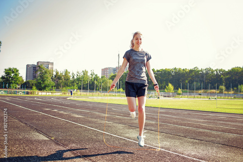 Young woman with jump rope on a running track