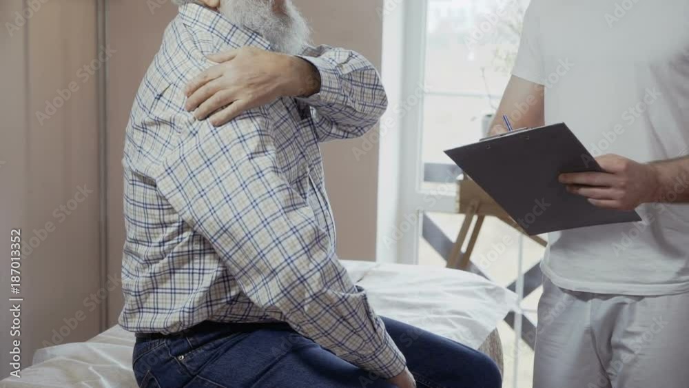 Senior man complain to doctor about pain in shoulder Senior man complain to doctor about pain in shoulder