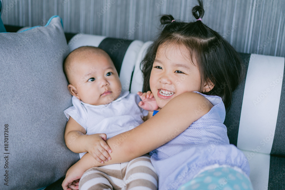 Φωτογραφία Little sister hugging and kissing her baby brother