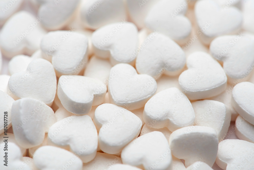 Pharmacy theme. White pills in the form of hearts on white background. Pharmacy theme. White pills in the form of hearts on white background.