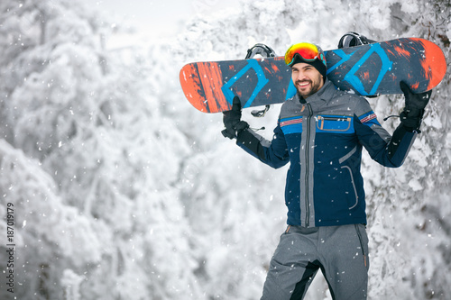 Sportsman holding ski board and return from skiing terrain