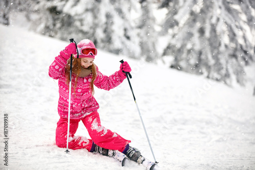 Girl on ski terrain practice to raise from snowy terrain