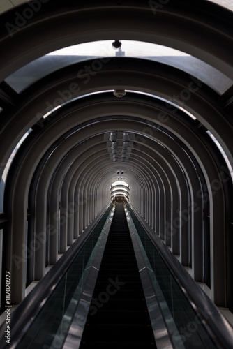 Fototapeta Naklejka Na Ścianę i Meble -  Diminishing perspective in a futuristic escalator tube, where does this tunnel bring us to?