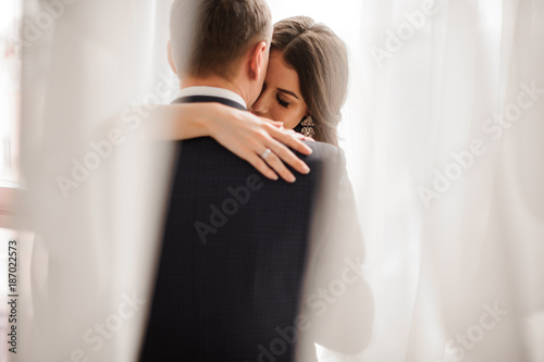Foto couple in love - bride and groom - gently embracing on a white background
