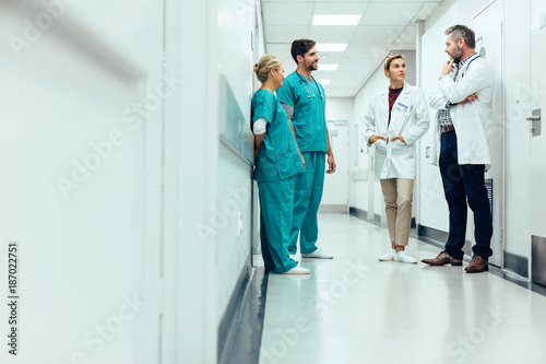 Team of doctors having discussion in hospital corridor