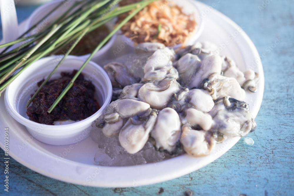 Fresh oyster on a plate with vegetable and seafood sauce Fresh oyster on a plate with vegetable and seafood sauce