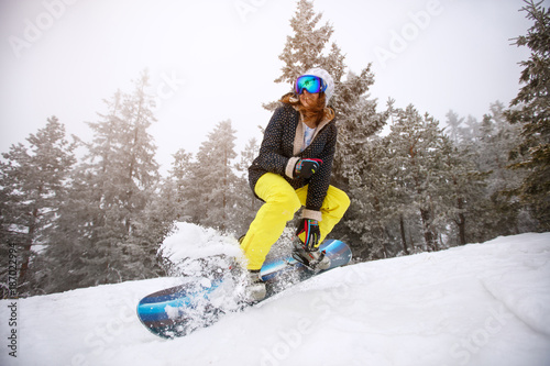 Snowboarder girl in action on ski-run