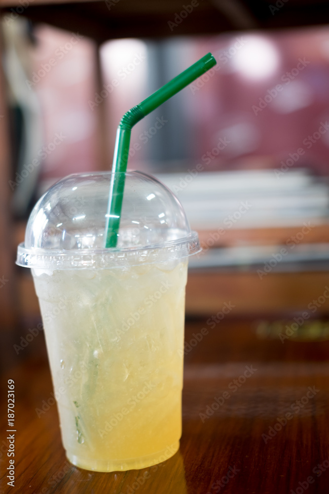 Ice green tea with lemon and honey in takeaway glass Ice green tea with lemon and honey in takeaway glass