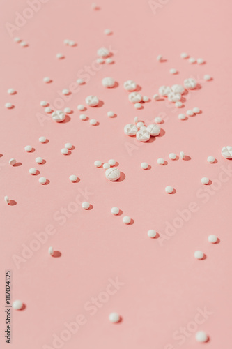White pills on pink