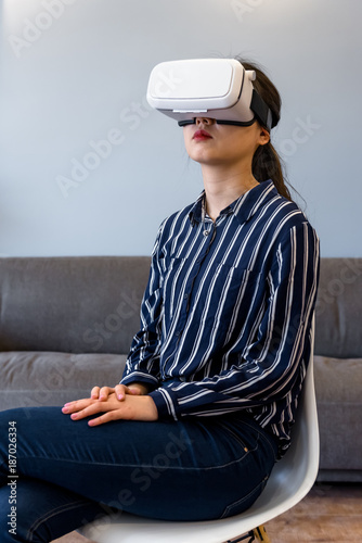 Young woman wearing virtual reality headset at home photo