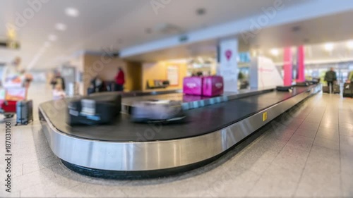 Time-lapse of modern airport luggage conveyor belt. People come from airplane, waiting and picking their bags and cases and leave. Tilt-Shift effect.