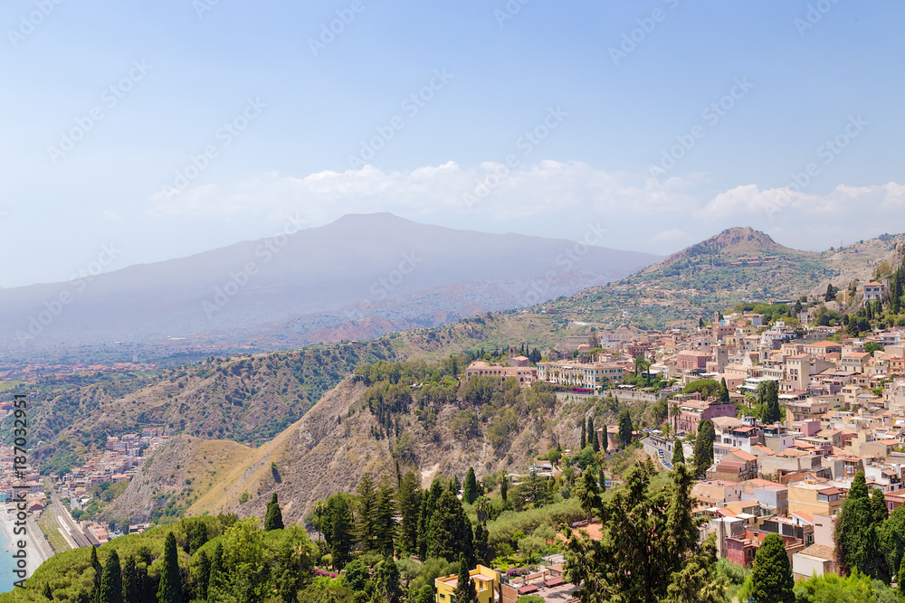 Taormina, Sicily, Italy. The historical center of the city on the mountainside and Etna volcano in the background
