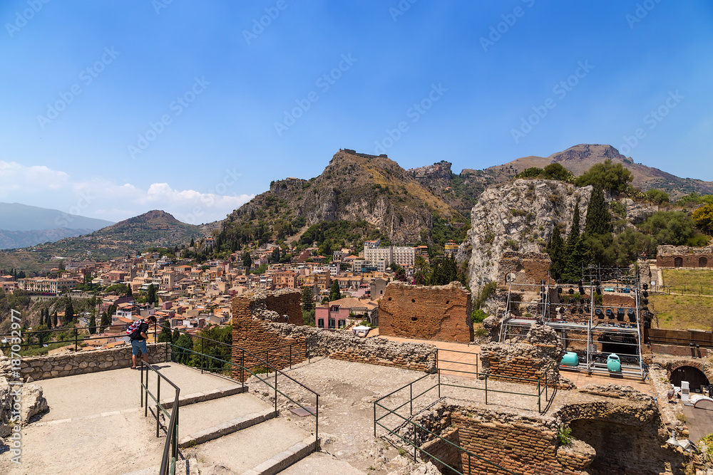 Taormina, Sicily, Italy. Ruins of the Greek theater (III century BC) and a picturesque view of the city against the backdrop of the mountains