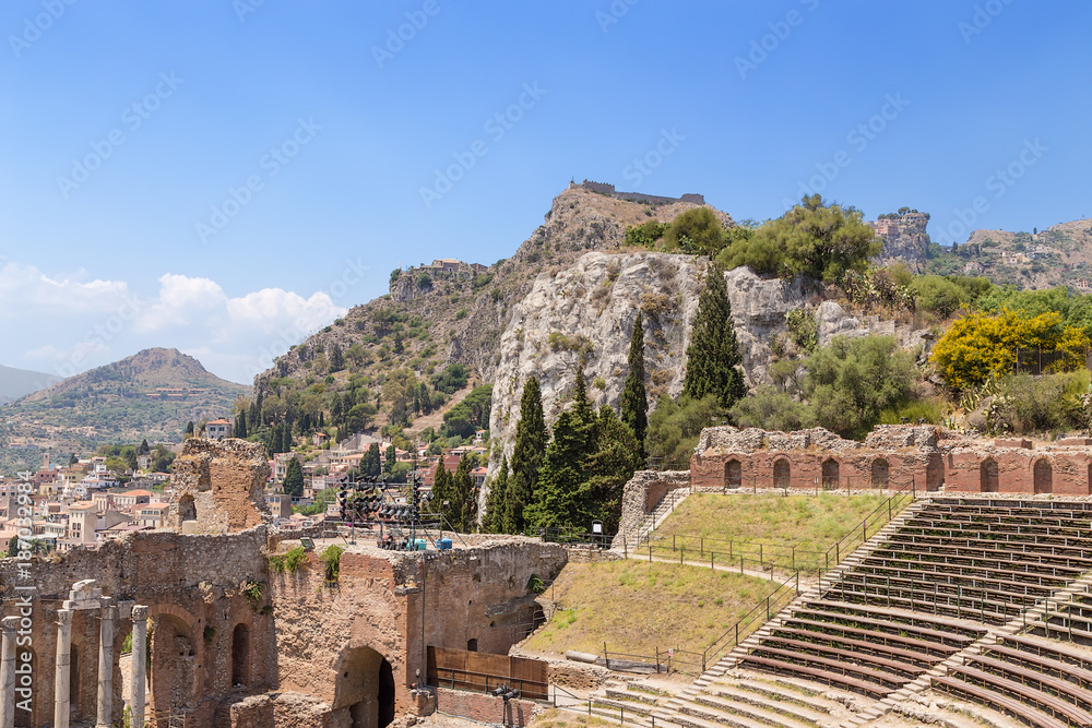 Taormina, Sicily, Italy. Ruins of the Greek theater (III century BC) and picturesque cliffs over the city