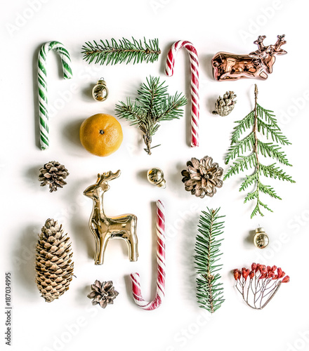New Year's unusual composition with spruce branches, sweets, mandarin, cones and gold deer. View from above. Copy space