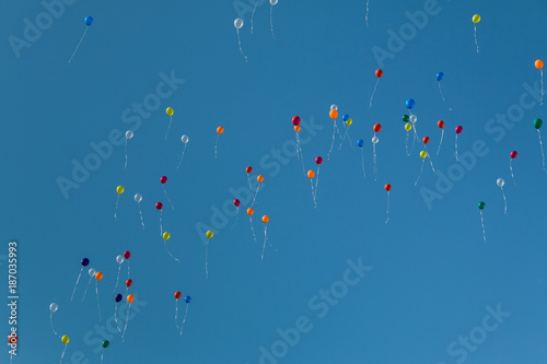 Colorful party balloons floating in the sky photo