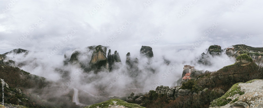 panorama of mystic rockformations of meteora covered in clouds - meteora - greece