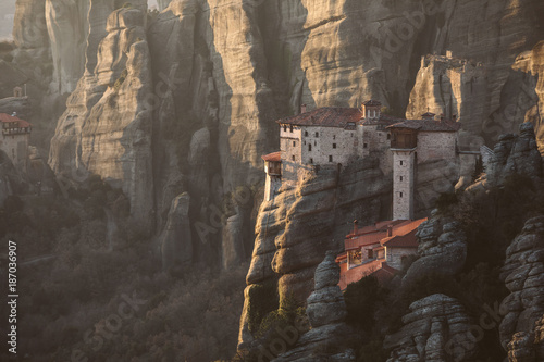 holy monastery built on top of sand pillars at sunset - meteora - greece