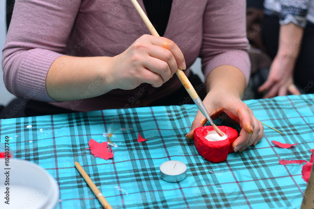 Woman decorating heart-shaped articles for Valentine's day. Woman decorating heart shaped cookies with pink cream. Cookies for Valentine's Day Woman decorating heart-shaped articles for Valentine's day. Woman decorating heart shaped cookies with pink cream. Cookies for Valentine's Day