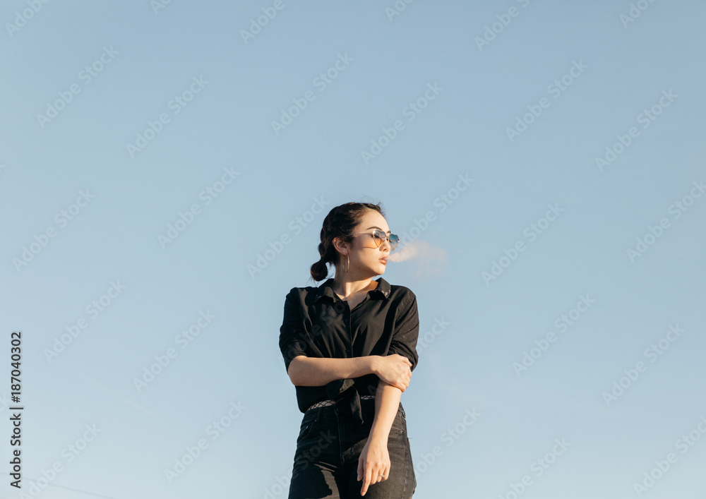 young woman smoking with cloud puff smoke in front of face young woman smoking with cloud puff smoke in front of face