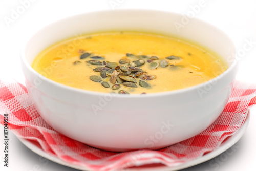 pumpkin soup with seeds in white bowl, hokkaido soup