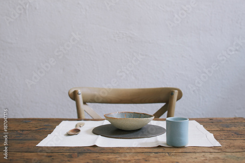 Old table and chair with craf ceramic tableset photo