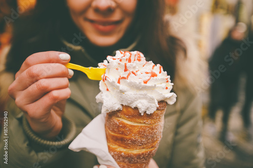Photography trdelnik or Trdlo with cream in the hands of a beautiful winter girl in the Czec
