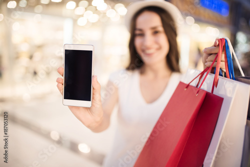 Order any product on the Internet. A woman with shopping bags shows the phone's screen directly to the camera