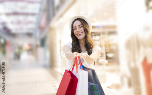 Smiling woman with shopping bags in the big mall