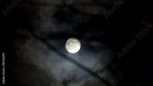 Black clouds run through the night sky against the background of the cold moon