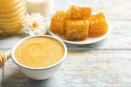 Bowl with delicious honey on table, closeup