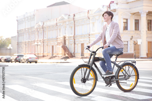 Hipster teenager riding bicycle outdoors