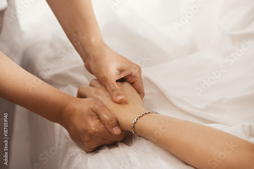 Therapist doing a pressure point massage for woman's hand
