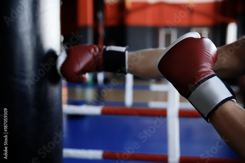 Boxer training with punchbag in gym © Africa Studio
