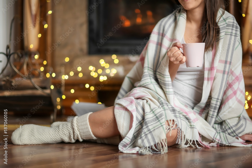 Φωτογραφία Young woman relaxing while drinking tea in living room decorated for winter holi