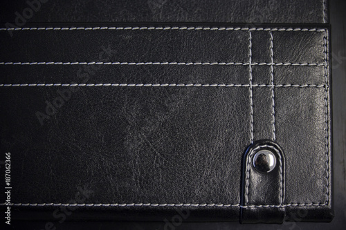 A leather stitched background with a button