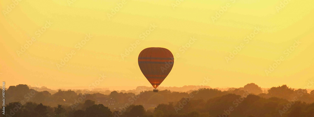 Fototapeta premium Heißluftballon am Abendhimmel Panorama