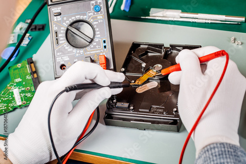 man repairing hard drive in service center. Repairing and fixing service in lab. Electronics repair service concept.